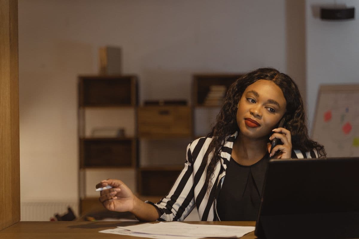 Agent au téléphone dans un bureau, illustrant le poste d'Agent Executive Admin, collecte de prêts, administration et Shopify.